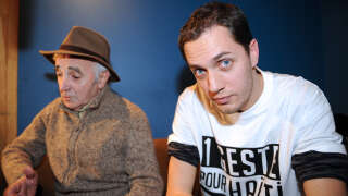 French singer Charles Aznavour (L) and Slam poet Grand Corps Malade addresses journalists while recording, with a dozen of French rappers and pop stars, a music video to raise funds for quake-stricken Haiti, on January 15, 2010 in Paris. 