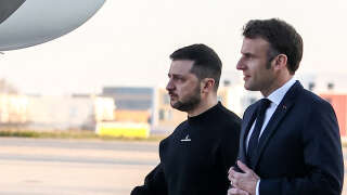 France's President Emmanuel Macron (R) and Ukrainian President Volodymyr Zelensky walk on the tarmac of Velizy-Villacoublay airbase as they prepare to board a flight together, en route to Brussels for a summit at EU parliament, on February 9, 2023. - Ukraine's President is set to attend an EU summit in Brussels on February 9, 2023, as the guest of honour where he will press allies to deliver fighter jets 