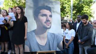 BFM TV journalist Maxime Brandstaetter (R), who was in Ukraine with his colleague Frederic Leclerc-Imhoff, stands with mourners next to a portrait of French journalist killed in Ukraine Frederic Leclerc-Imhoff during a tribute rally on the Place de la Republique in Paris, on June 10, 2022. - French BFM TV news channel journalist Frederic Leclerc-Imhoff was killed in eastern Ukraine on June 1, 2022, while on board a humanitarian bus with civilians fleeing Russian bombardment. (Photo by Bertrand GUAY / AFP)