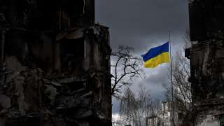 Un drapeau ukrainien flotte entre des bâtiments détruits lors d’un bombardement à Borodianka, dans la région de Kiev, le 17 avril 2022.