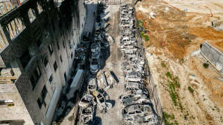 Cette photo prise le 27 février 2023 montre une vue aérienne d’une casse où des voitures ont été incendiées pendant la nuit, dans la ville palestinienne de Huwara près de Naplouse en Cisjordanie occupée.