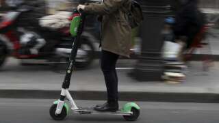 A woman uses an Lime-S electric scooter of the US company Lime in Paris on March 3, 2019 in Paris. (Photo by KENZO TRIBOUILLARD / AFP)