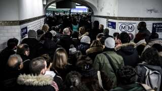 (FILES) In this file photo taken on December 12, 2019, commuters queue to access the platform of the subway line 1 during a strike of public transports operator SNCF and RATP employees, in Paris. - France braces for major transport blockages, with mass strikes and protests set to hit the country on March 7 in objection to the planned boost of the age of retirement from 62 to 64. (Photo by Philippe LOPEZ / AFP)