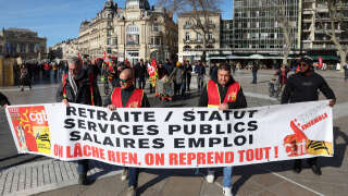 French union General Confederation of Labour's (CGT) unionists hold a banner during a demonstration on a 8th day of strikes and protests across the country against the government's proposed pensions overhaul in Montpellier on March 15, 2023. - France faces another day of strikes over highly contested pension reforms which President appears on the verge of pushing through despite months of protests. As the legislation enters the final stretch in parliament, trade unions are set to make another attempt to pressure the government and lawmakers into rejecting the proposed hike in the retirement age to 64. (Photo by Pascal GUYOT / AFP)