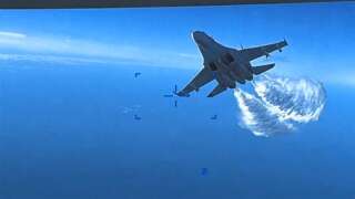 This handout image taken from video released by U.S. European Command (USEUCOM) on March 16, 2023,  shows onboard footage from a U.S. Air Force MQ-9 drone as it is approached the first time by a Russian SU-27 aircraft jettissoning fuel, over The Black Sea on March 14, 2023. - Moscow said that it would try to retrieve the wreckage of a US military drone that crashed over the Black Sea in a confrontation Washington blamed on two Russian fighter jets. Russia also warned that it would react 