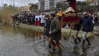 Penitents carry a statue of Saint-Gauderique, Patron Saint of Farmers, into the Tet river in Perpignan, south western France on March 18, 2023, during a ceremony to ask for rain amidst the drought that is hitting the Pyrénées-Orientales region. -  (Photo by RAYMOND ROIG / AFP)