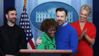 WASHINGTON, DC - MARCH 20: Comedian Jason Sudeikis of the Apple TV+ comedy series Ted Lasso embraces White House Press Secretary Karine Jean-Pierre as other cast members Brett Goldstein (L) and Hannah Waddingham look on during a White House daily news briefing at the James S. Brady Press Briefing Room on March 20, 2023 in Washington, DC. Sudeikis and the cast of Ted Lasso are at the White House to meet with President Joe Biden and first lady Jill Biden to discuss “the importance of addressing your mental health to promote overall well-being.”   Alex Wong/Getty Images/AFP (Photo by ALEX WONG / GETTY IMAGES NORTH AMERICA / Getty Images via AFP)