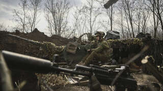 An Ukrainian serviceman sits on an anti-air gun near Bakhmut, on March 24, 2023. (Photo by Aris Messinis / AFP)