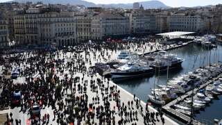 Protesters gather on the Vieux Port (Old Port) during a demonstration after the government pushed a pensions reform through parliament without a vote, using the article 49.3 of the constitution, in Marseille, southeastern France, on March 28, 2023. - France faces another day of strikes and protests nearly two weeks after the president bypassed parliament to pass a pensions overhaul that is sparking turmoil in the country, with unions vowing no let-up in mass protests to get the government to back down.  The day of action is the tenth such mobilization since protests started in mid-January against the law, which includes raising the retirement age from 62 to 64. (Photo by CHRISTOPHE SIMON / AFP)