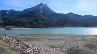 A photograph taken on March 16, 2023 shows the lake Serre-Poncon partially dry, near Embrun, in the French Alps. (Photo by Nicolas TUCAT / AFP)