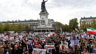 Protestors hold portraits of Mahsa Amini and Iranian who were arrested or killed in the recent uprising in Iran during a rally in solidarity with Iranian protestors, at the Place de la Republique in Paris, on October 29, 2022. - Iranian Mahsa Amini, 22, died in custody on September 16, 2022, three days after her arrest by the notorious morality police in Tehran for allegedly breaching the Islamic republic's strict dress code for women. (Photo by Behrouz MEHRI / AFP)