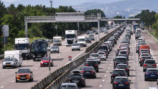 Motorists drive and queue in their vehicles on the A7 motorway between Lyon and Vienne, southeastern France, during a heavy traffic jam on the first major weekend of the French summer holidays, on July 10, 2021. (Photo by PHILIPPE DESMAZES / AFP)