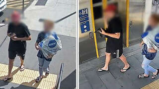 An undated handout framegrab received on April 6, 2023 from the Queensland Police Service shows a man (L) carrying a rare, wild platypus at a train station near Brisbane. - Police said on April 6 they were searching for two people spotted boarding a suburban train with the unusual piece of living luggage -- a rare wild platypus swaddled in a towel. (Photo by Handout / QUEENSLAND POLICE SERVICE / AFP) / ----EDITORS NOTE ----RESTRICTED TO EDITORIAL USE MANDATORY CREDIT 