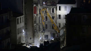 An excavator moves rubble at 'rue Tivoli' after a building collapsed in the same street, in Marseille, southern France, on April 9, 2023. - An apartment building collapsed in an apparent explosion on April 9, 2023 in the French Mediterranean city of Marseille, injuring five people, with authorities warning up to 10 victims could be under the burning rubble. (Photo by CLEMENT MAHOUDEAU / AFP)