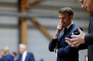 French President Emmanuel Macron (L) listens to Mathis CEO Frank Mathis (R) during a visit to Mathis, a company specialised in large wooden buildings, in Muttersholtz, eastern France on April 19, 2023. - Macron, whose reforms including an increase to the pension age have earned him widespread animosity in recent weeks, makes a visit on the theme of reindustrialisation. (Photo by Ludovic MARIN / POOL / AFP)