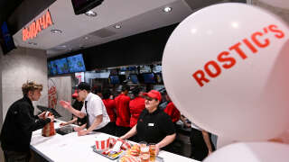 A visitor receives an order in the Russian version of a former KFC's restaurant, now Rostic's during the opening ceremony in Moscow on April 25, 2023. - The Russian incarnation of KFC opened its first restaurant in Moscow on April 25, 2023 after the American fast food chain exited the country over the Kremlin's offensives in Ukraine. (Photo by Kirill KUDRYAVTSEV / AFP)