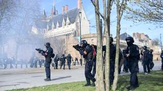 French police officers (BAC) use LBD guns during clashes with demonstrators taking part in a rally after the government pushed a pensions reform through parliament without a vote, using the article 49.3 of the constitution, in Nantes, western France, on March 28, 2023. - France faces another day of strikes and protests nearly two weeks after the president bypassed parliament to pass a pensions overhaul that is sparking turmoil in the country, with unions vowing no let-up in mass protests to get the government to back down. The day of action is the tenth such mobilisation since protests started in mid-January against the law, which includes raising the retirement age from 62 to 64. (Photo by Sebastien SALOM-GOMIS / AFP)