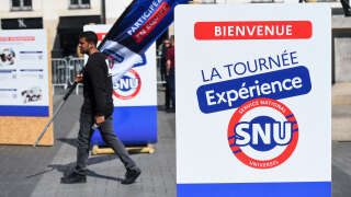 A man walks by a promotional campaign village for the Universal National Service, or SNU (Service National Universel), in Nantes, Western France, on April 19, 2023. (Photo by Sebastien SALOM-GOMIS / AFP)