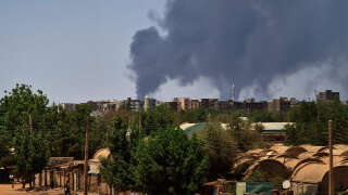 Smoke billows over buildings in Khartoum on May 1, 2023 as deadly clashes between rival generals' forces have entered their third week. - The top United Nations humanitarian official is heading to the Sudan region due to the 