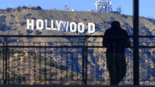 A man views the Hollywood sign from a walkway at a Hollywood shopping mall on October 16, 2017 in Hollywood, California. (Photo by FREDERIC J. BROWN / AFP)