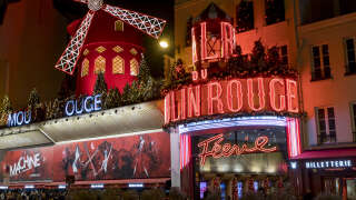 PARIS, FRANCE - DECEMBER 30: Moulin Rouge on December 30, 2019 in Paris, France.  Moulin Rouge is a cabaret in Paris.  The original house, which burned down in 1915, was co-founded in 1889 by Charles Zidler and Joseph Oller.  Moulin Rouge is best known as the birthplace of the modern form of the can-can dance.  Moulin Rouge is a tourist attraction, offering musical dance entertainment.  (Photo by Athanasios Gioumpasis/Getty Images)