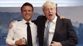 France's President Emmanuel Macron (L) and British Prime Minister Boris Johnson pose for a picture during bilateral talks on June 26, 2022, in Elmau Castle, southern Germany, on the sidelines of a summit of the Group of Seven rich nations (G7). G7 leaders will be under pressure to hold fast to climate pledges when they meet in Bavaria from June 26 to 28, as Russia's energy cuts trigger a dash back to planet-heating fossil fuels. (Photo by BENOIT TESSIER / POOL / AFP)