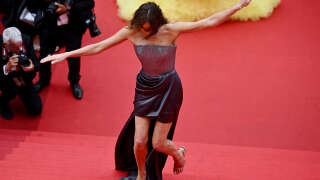 French-Italian model and musician Carla Bruni struggles with her dress as she arrives for the screening of the film 