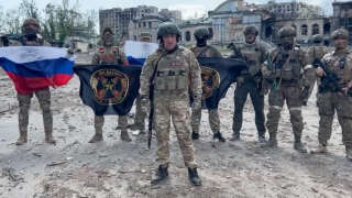 This video grab taken from a handout footage posted on May 20, 2023 on the Telegram account of the press service of Concord -- a company linked to the chief of Russian mercenary group Wagner, Yevgeny Prigozhin -- shows Yevgeny Prigozhin holding a Russian national flag in front of his soldiers holding Wagner Group's flags in Bakhmut, amid the Russian invasion of Ukraine. Russia's private army Wagner claimed on May 20, 2023, the total control of the east Ukrainian city of Bakhmut, the epicentre of fighting, as Kyiv said the battle was continuing but admitted the situation was 