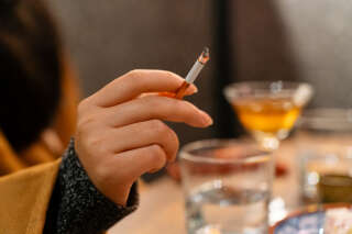 Close-up shot of a woman smoking in a tavern