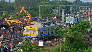 Des policiers inspectent les wagons détruits par l’impresionnante collisions de trois trains vendredi près de Balasore, dans l’État indien d’Odisha.
