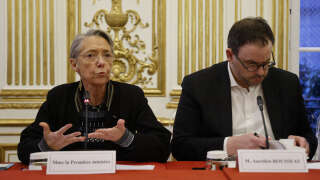 French Prime Minister Elisabeth Borne speaks next to her chief of staff Aurelien Rousseau during a meeting with MPs of the ruling coalition at the Hotel Matignon in Paris, on March 27, 2023. (Photo by Ludovic MARIN / AFP)
