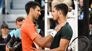 Spain's Carlos Alcaraz (R) and Serbia's Novak Djokovic shake hands at the end of their 2022 ATP Tour Madrid Open tennis tournament men's singles semi-final match at the Caja Magica in Madrid on May 7, 2022. (Photo by Pierre-Philippe MARCOU / AFP)