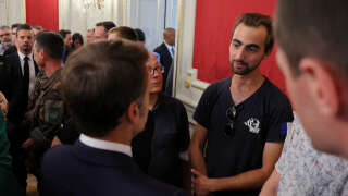 French President Emmanuel Macron (L) talks with Henri (R), the 24-year-old known as the 'backpack hero', who suffered minor stab wounds as he tried to stop the fleeing suspect, during a meeting with rescue forces at the Haute-Savoie prefecture, a day after a mass stabbing in a park, in Annecy, in the French Alps, France, on June 9, 2023. A Syrian refugee suspected of stabbing six people in the French Alpine town of Annecy on June 8, 2023 did not appear to have a 