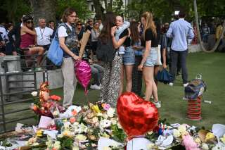 People hug in front of flowers and candles for the victims of a stabbing attack that occured the day before in the 'Jardins de l'Europe' parc in Annecy, French Alps, on June 9, 2023. A man armed with a knife stabbed four preschool children and injured two adults by a lake in the French Alps on June 8 in an attack that sent shock waves through the country. The suspect is a Syrian in his early 30s who was granted refugee status in Sweden in April, a police source told AFP. He was arrested at the scene. (Photo by OLIVIER CHASSIGNOLE / AFP)