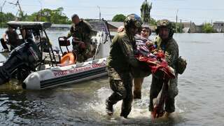 Des militaires ukrainiens aident à décharger un résident handicapé d’un bateau lors d’une évacuation d’une zone inondée à Kherson, le 8 juin 2023.