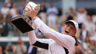 Poland's Iga Swiatek raises the trophy Suzanne Lenglen following her victory over Czech Republic's Karolina Muchova during their women's singles final match on day fourteen of the Roland-Garros Open tennis tournament at the Court Philippe-Chatrier in Paris on June 10, 2023. (Photo by Thomas SAMSON / AFP)