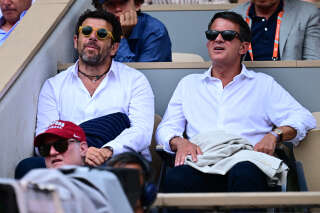 French singer and actor Patrick Bruel (L) former French prime minister Manuel Valls attend the men's singles final match between Serbia's Novak Djokovic and Norway's Casper Ruud on day fifteen of the Roland-Garros Open tennis tournament at the Court Philippe-Chatrier in Paris on June 11, 2023. (Photo by Emmanuel DUNAND / AFP)