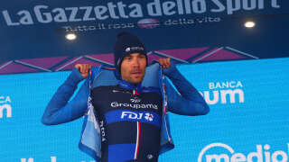 Groupama - FDJ's French rider Thibaut Pinot celebrates his best climber's blue jersey on the podium after the nineteenth stage of the Giro d'Italia 2023 cycling race, 183 km between Longarone and Tre Cime di Lavaredo (rifugio Auronzo) on May 26, 2023. (Photo by Luca Bettini / AFP)