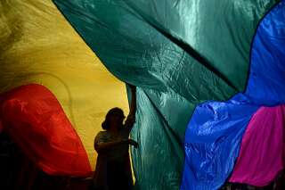 A woman is seen under a giant flag during the annual Gay Pride parade also known as 