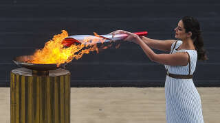 19 October 2021, Greece, Athen: Xanthi Georgiou, actress from Greece, plays the role of the High Priestess and lights the torch with the Olympic flame during the Olympic Flame Presentation Ceremony at the Panathenaean Stadium. The Winter Olympics will be held in Beijing from February 4-20, 2022. Photo: Angelos Tzortzinis/dpa (Photo by Angelos Tzortzinis/picture alliance via Getty Images)