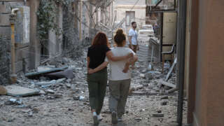 Des habitants se promènent parmi les décombres des bâtiments endommagés par des tirs de missiles russes à Odessa, le 23 juillet 2023.