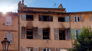 This photograph shows the burnt facade of a five-storey building in the historic centre of Grasse, on August 13, 2023, after at least three people were killed, one seriously injured and sixteen slightly injured in a fire that broke out early on the morning. A security cordon was set up around this historic square in Grasse. At least three of the building's five upper floors were affected by the fire, with part of the facade blackened, according to an AFP correspondent on the scene. (Photo by Vincent-Xavier MORVAN / AFP)