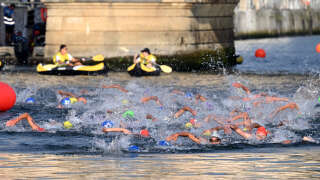 Triathlon athletes swim in the Seine river during the men's 2023 World Triathlon Olympic Games Test Event in Paris, on August 18, 2023. From August 17 to 20, 2023, Paris 2024 is organising four triathlon events to test several arrangements, such as the sports operations, one year before the Paris 2024 Olympic and Paralympic Games. The swim familiarisation event follows the cancellation on August 6 of the pre-Olympics test swimming competition due to excessive pollution which forced organisers to cancel the pre-Olympics event. (Photo by Bertrand GUAY / AFP)