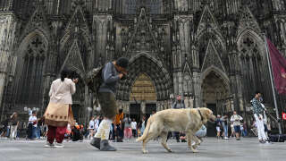 Tourists are seen in front of the Cathedral in Cologne, western Germany, on June 27, 2023. German investigators staged raids in the archdiocese of Cologne in a perjury probe against Cardinal Rainer Maria Woelki linked to media coverage of Catholic Church sex abuse scandals. Cologne prosecutors said in a statement that six sites including Woelki's residence and an IT centre dealing with Church emails had been searched by around 30 police officers. (Photo by Ina FASSBENDER / AFP)
