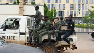 Police officer ride on the back of a pick-up truck as they patrol in Niamey on August 21, 2023. (Photo by AFP)