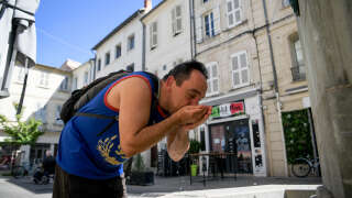 Un homme boit de l’eau à une fontaine publique. Météo-France a émis pour vendredi une alerte rouge canicule pour 19 départements.