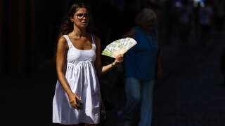 Une femme utilise un éventail alors qu’elle marche dans une rue de Toulouse, dans le sud-ouest de la France, le 23 août 2023. 42,4 °C ont été atteints au plus chaud de la journée, le précédent record remontait à août 2003.