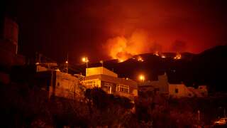 A picture taken in the night of August 19, 2023 shows the fronts of the forest fire on hills above houses, in the Guimar valley on the Canary Island of Tenerife. The blaze, which officials say is the most 