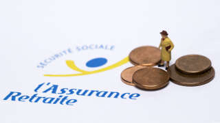 This picture shows a figurine displayed next to Euro cents and the logo of the pension insurance, on August 27, 2018 in Paris. (Photo by JOEL SAGET / AFP)