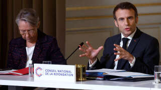 France's President Emmanuel Macron (L), flanked by France's Prime Minister Elisabeth Borne, delivers a speech during the second plenary session of the National Refoundation Council (Conseil national de la Refondation) (CNR) at the presidential Elysee Palace in Paris on December 12, 2022. The second plenary session of the CNR, to make a 
